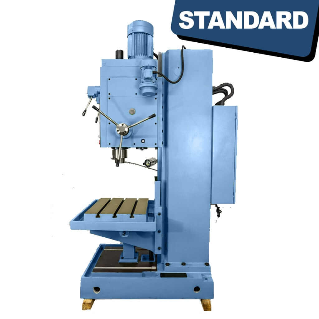 A side view of the STANDARD DC-50 Heavy Duty Column Type Drilling Pedestal Machine. The machine showcases a vertical column with a drilling head at the top, mounted on a solid base. It displays adjustable handles, a robust frame, and control panels, illustrating its industrial-grade design for precise and heavy-duty drilling operations.