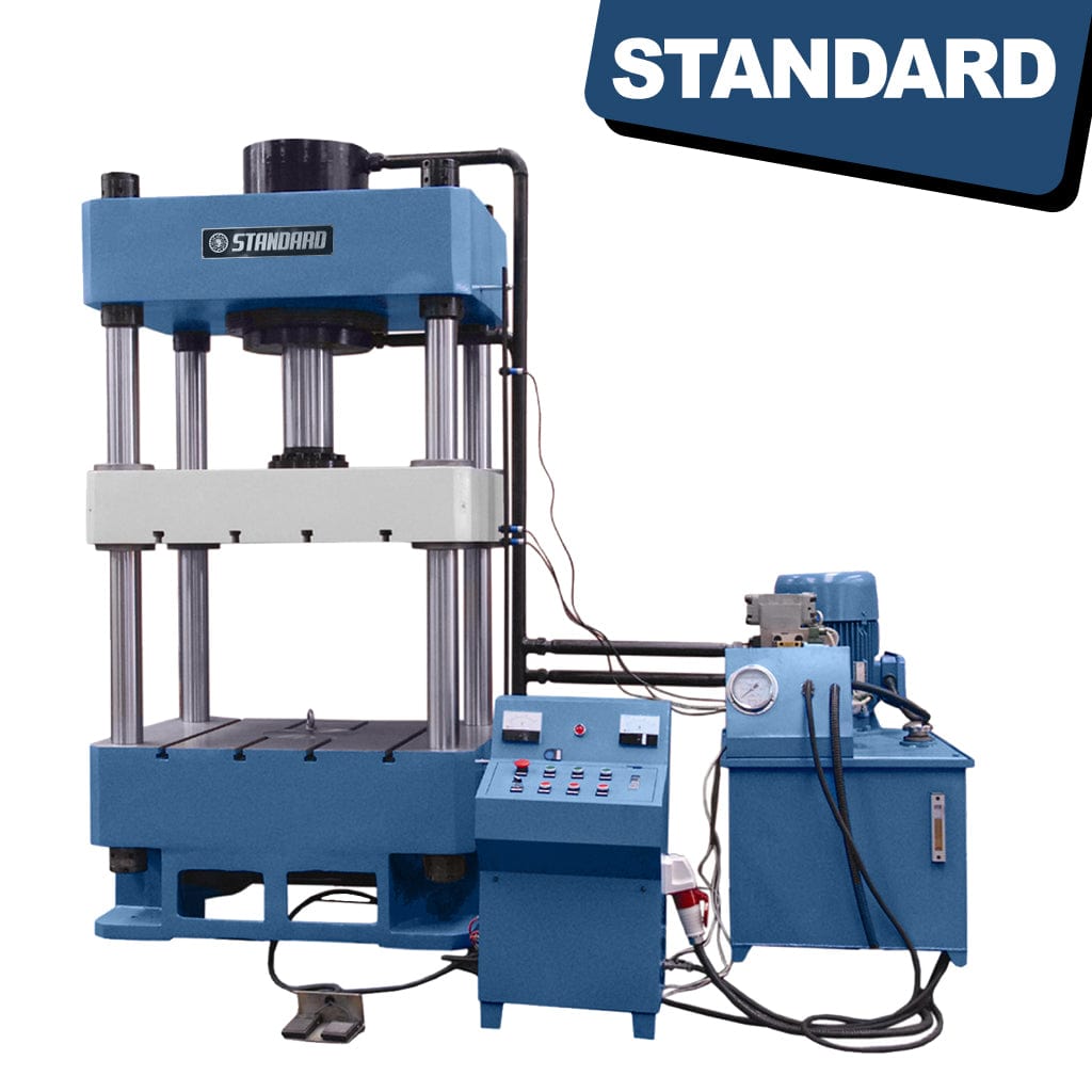 A large STANDARD H4P-600 4-post Hydraulic Press with a 600-ton capacity. The press consists of sturdy metallic frames and hydraulic cylinders arranged in a vertical structure. It has a control panel on the side with various buttons and levers for operation.
